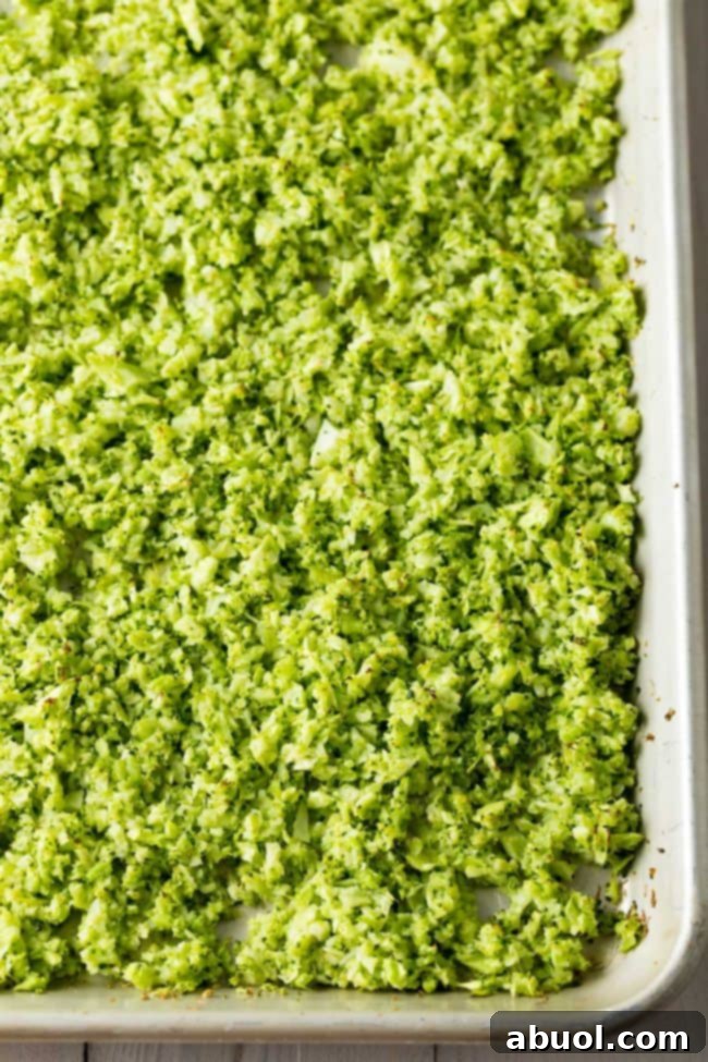 A sheet pan filled with golden-brown, perfectly roasted riced broccoli, illustrating the final product ready to be served as a healthy rice substitute.