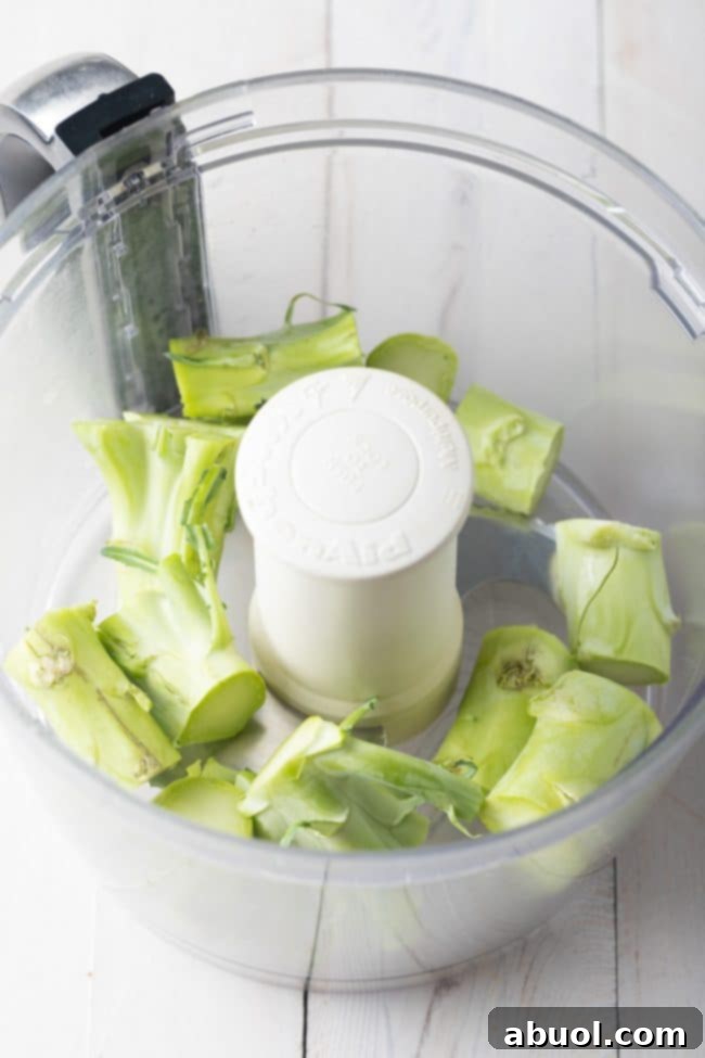 A visual guide showing the initial step of preparing broccoli stalks for ricing, illustrating the 'stalks first' method.