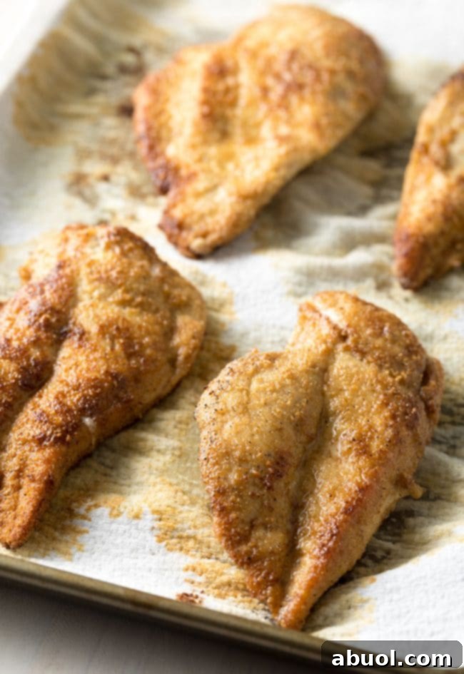 Close-up of golden brown chicken piccata frying in a skillet.