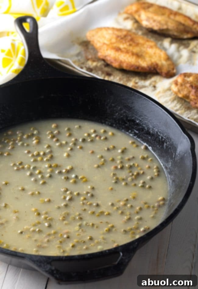 Lemon slices and capers in a pan, beginning to form the piccata sauce.