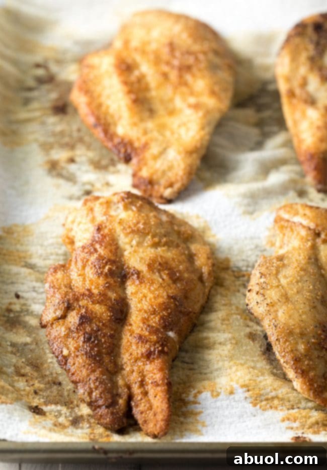 Crispy Chicken Piccata Recipe: Finished chicken piccata in a cast iron skillet, simmering in lemon sauce.