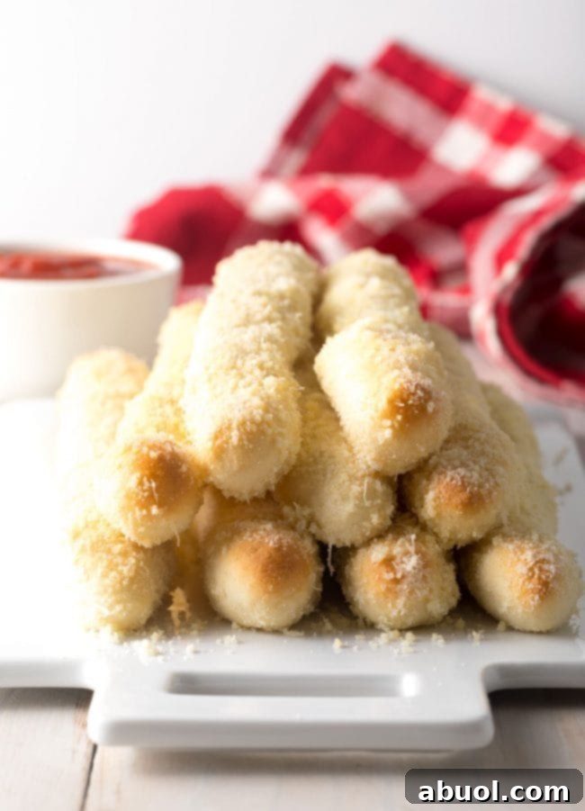 Crazy bread recipe - breadsticks stacked on platter with cheese