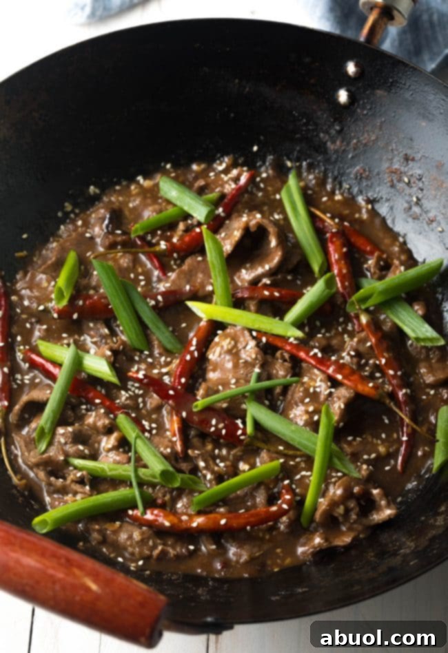 A sizzling, spicy hot Szechuan Beef dish served fresh in a wok, ready to be enjoyed.