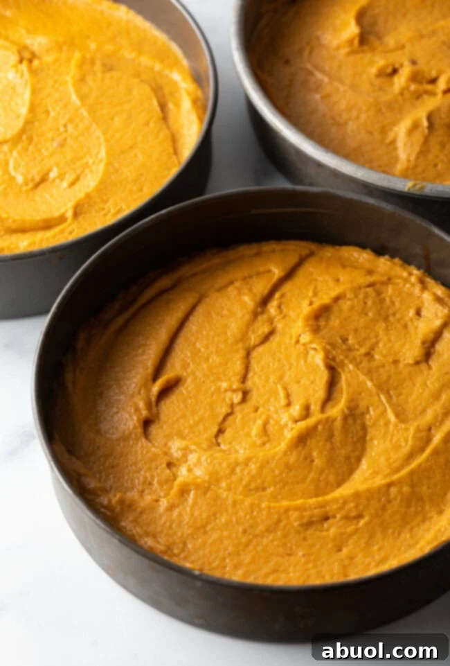 Spiced Autumn Pumpkin Cake 5 Cake batter poured into cake pans.