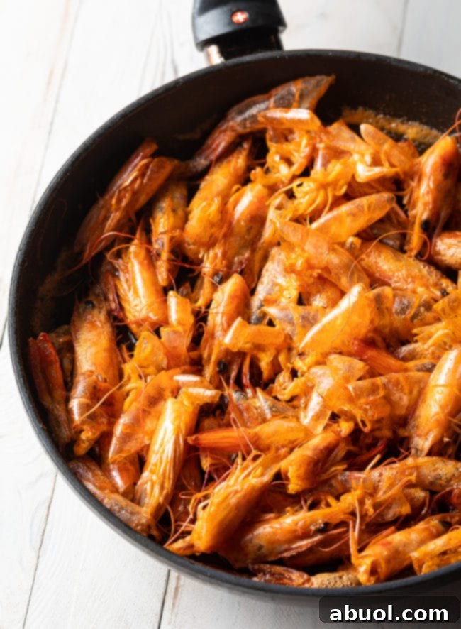 Spicy Thai Tom Yum Perfection 7 Making shrimp oil in a skillet with shrimp heads.