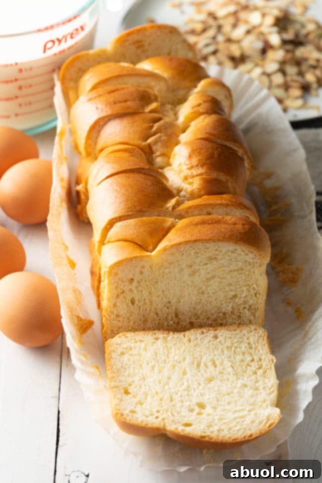 A freshly sliced loaf of brioche bread, showing its thick, even slices, ready for the custard soak.