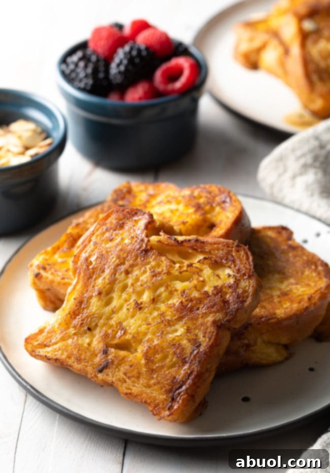 Multiple slices of beautifully cooked Pain Perdu arranged on a clean white plate, ready to be served.