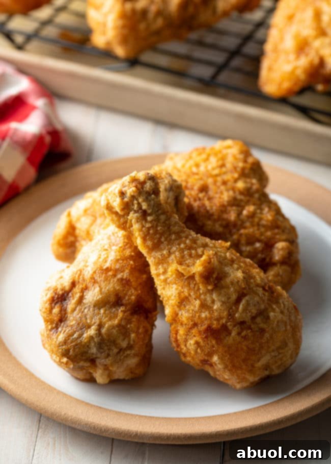 Three golden-brown pieces of crispy tavern fried chicken on a white plate, ready to be served.