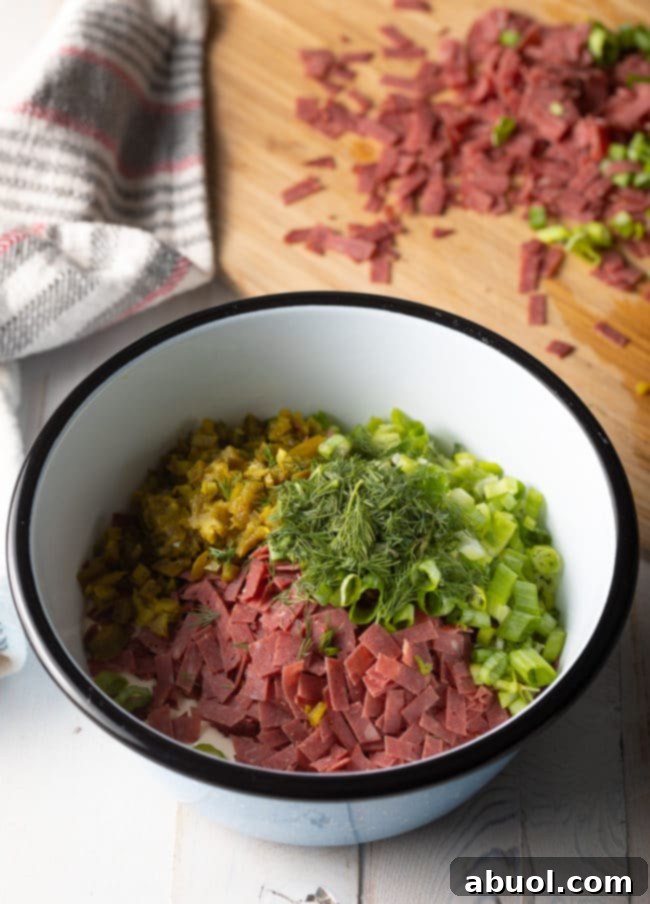 Bowl filled with ingredients for chipped beef dip before mixing. Visual guide for preparation.
