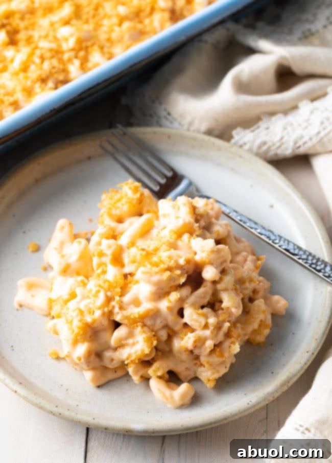 Homemade Mac and Cheese Perfection 14 Plate with a serving of this baked macaroni with a fork laying next to it.
