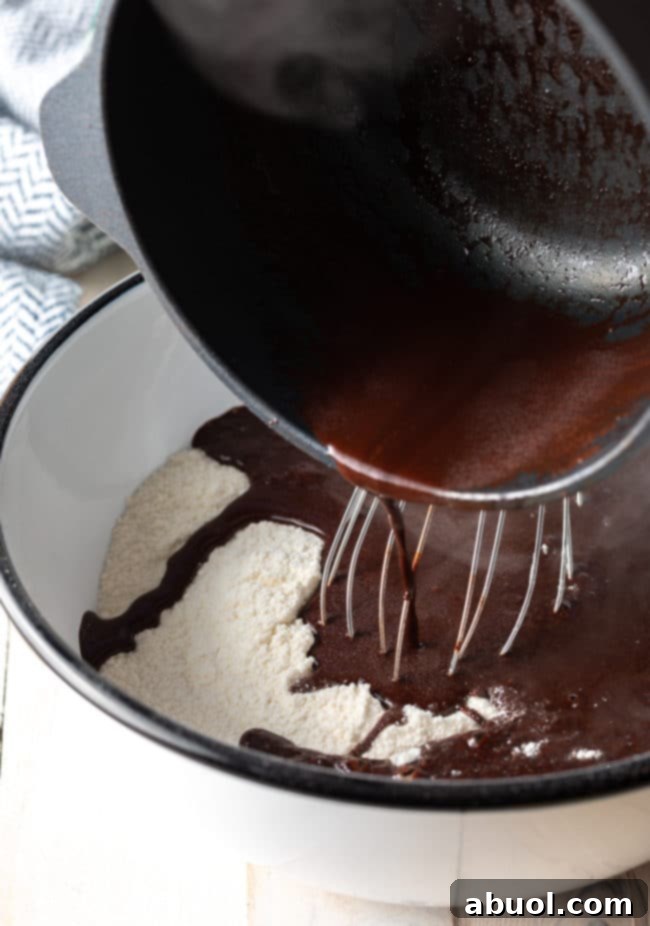 Pouring cocoa mixture into the flour mixture.