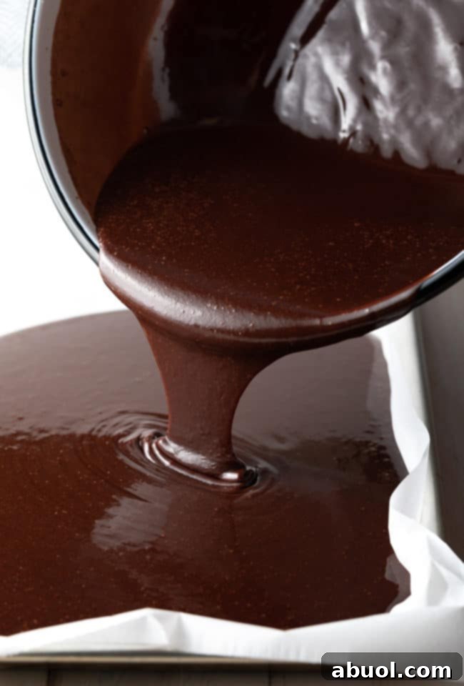 Pouring sheet cake batter into the sheet pan.