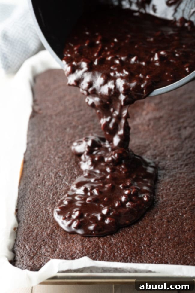 Pouring chocolate icing on top of sheet cake.