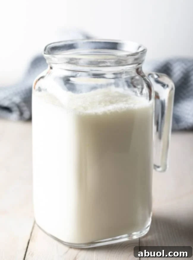 A charming glass pitcher filled with freshly made homemade buttermilk, ready for use.