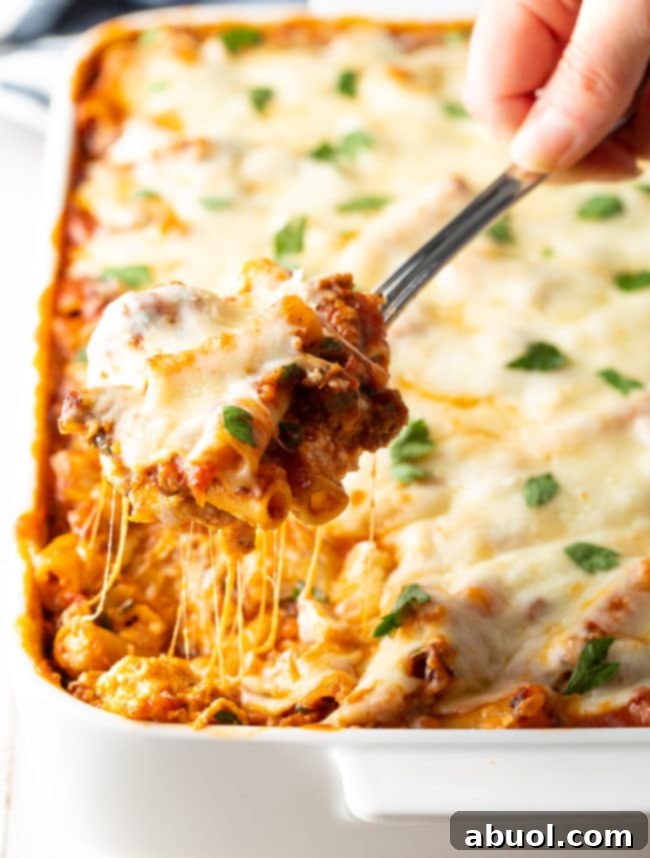 baked-ziti-with-ricotta Baked ziti with sausage and ricotta spooned up from a casserole dish, showing gooey cheese and rich meat sauce