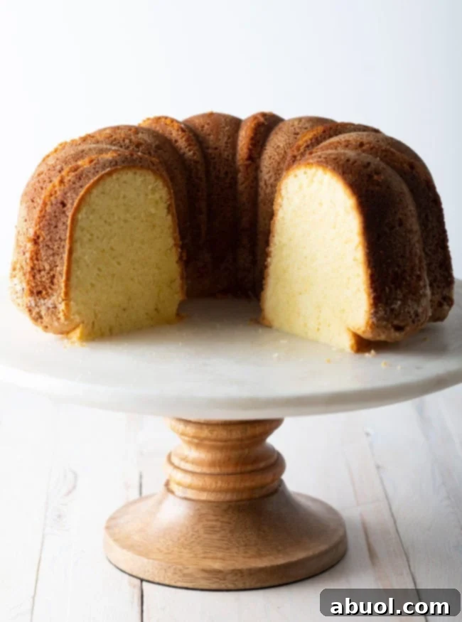 Side view of a cake stand showcasing a sliced bundt cake, revealing its perfect, moist internal texture.