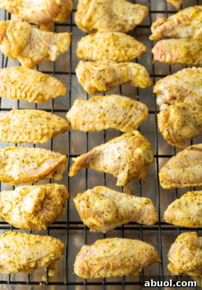 Crispy Baked Lemon Pepper Wings 11 Chicken wings arranged on a wire rack for baking.