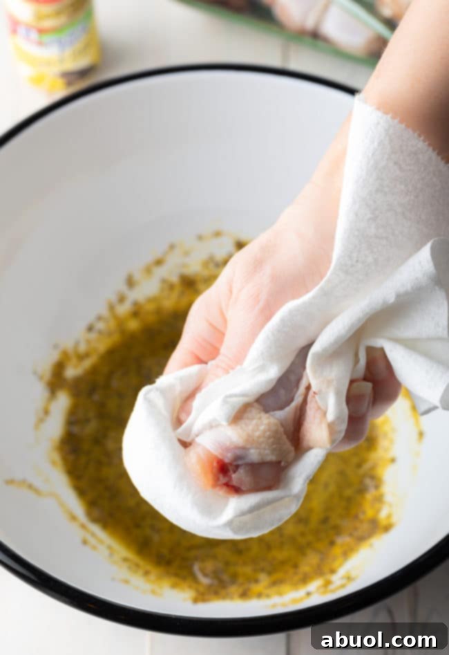 Crispy Baked Lemon Pepper Wings 8 Hands using paper towels to thoroughly dry individual chicken wings.