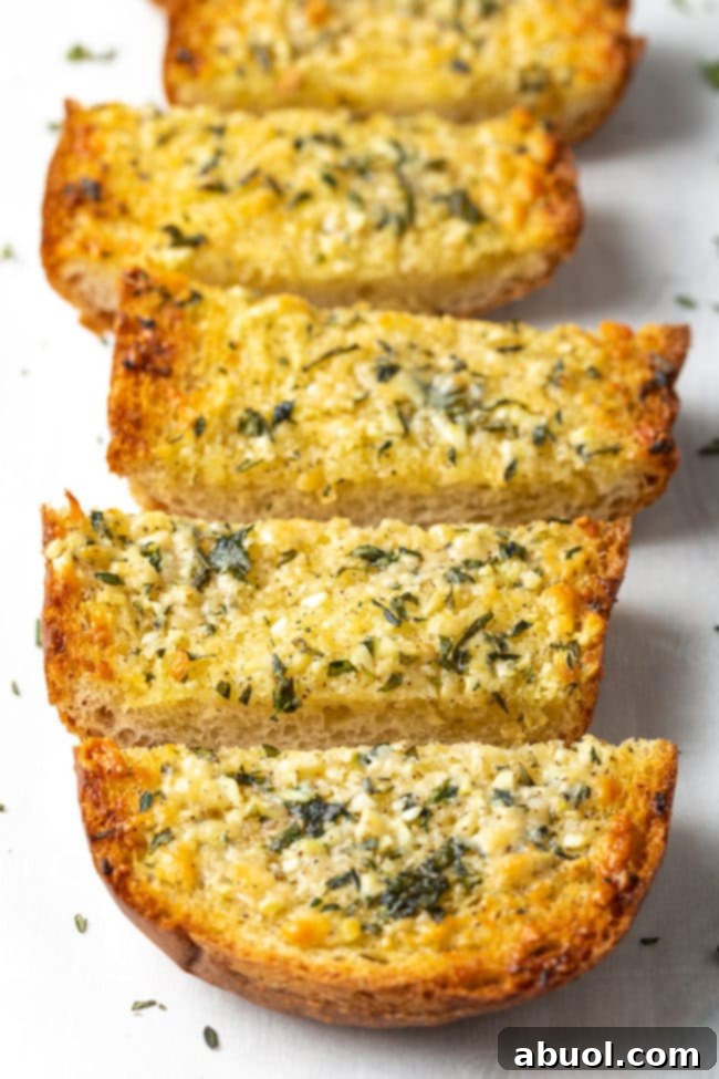 A loaf of homemade garlic bread sliced into 5 thick pieces.