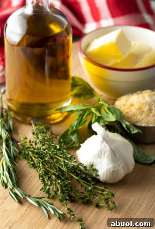 Ingredients you need: Whole fresh section of basil leaves, thyme, rosemary, plus a whole head of garlic, bowl of shaved parmesan, bowl of butter, and glass of olive oil.