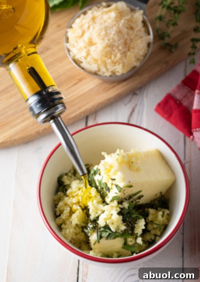 Adding oil from the bottle into a bowl with butter, minced garlic, and fresh herbs to make the easy garlic bread seasoning.