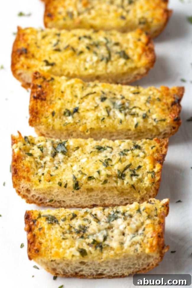 A loaf of homemade garlic bread sliced into 5 thick pieces.