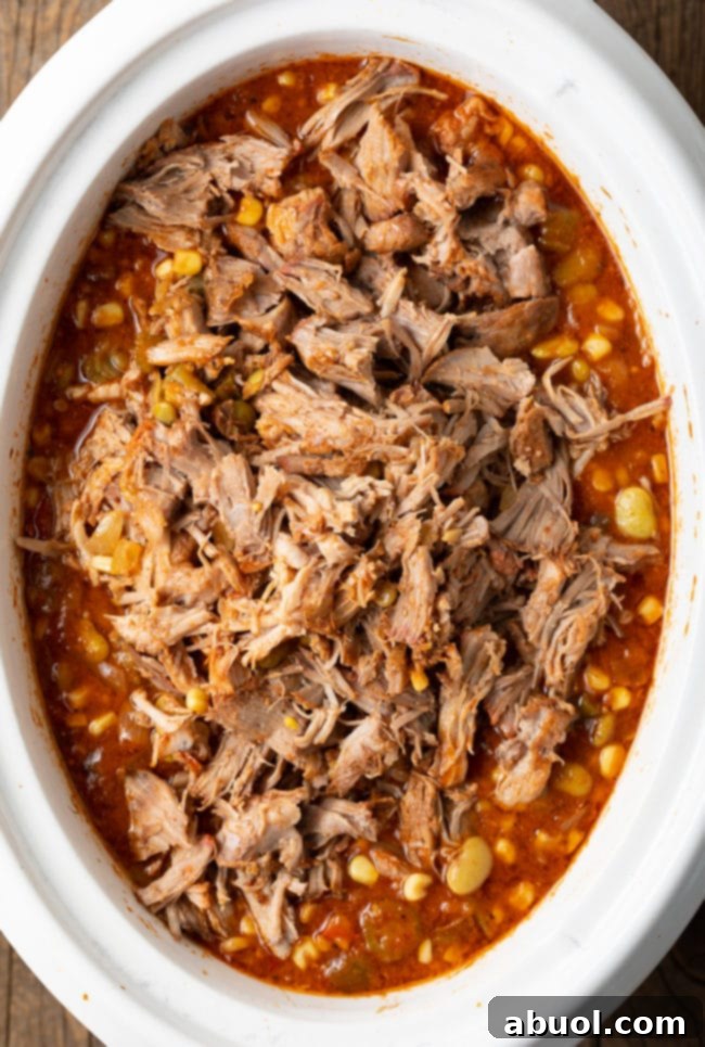 Set It and Forget It Brunswick Stew 7 Overhead view of Brunswick Stew simmering in a crockpot with shredded pork added, nearly ready to serve.