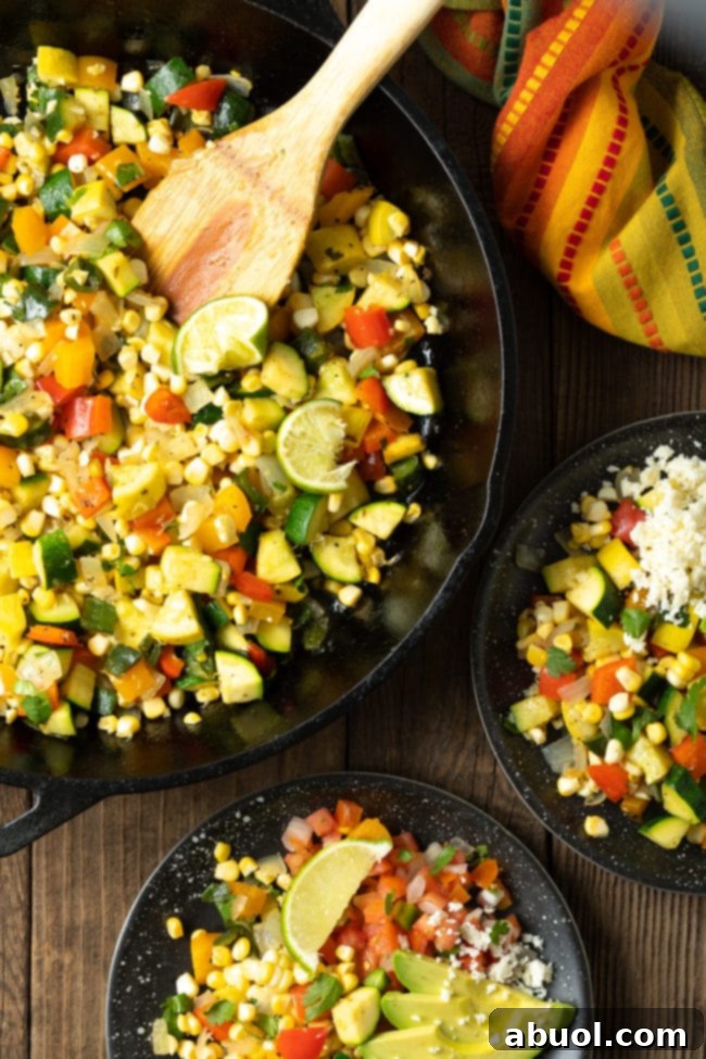 Sauteed vegetables in a cast iron skillet with some of it served on plates next to it. 