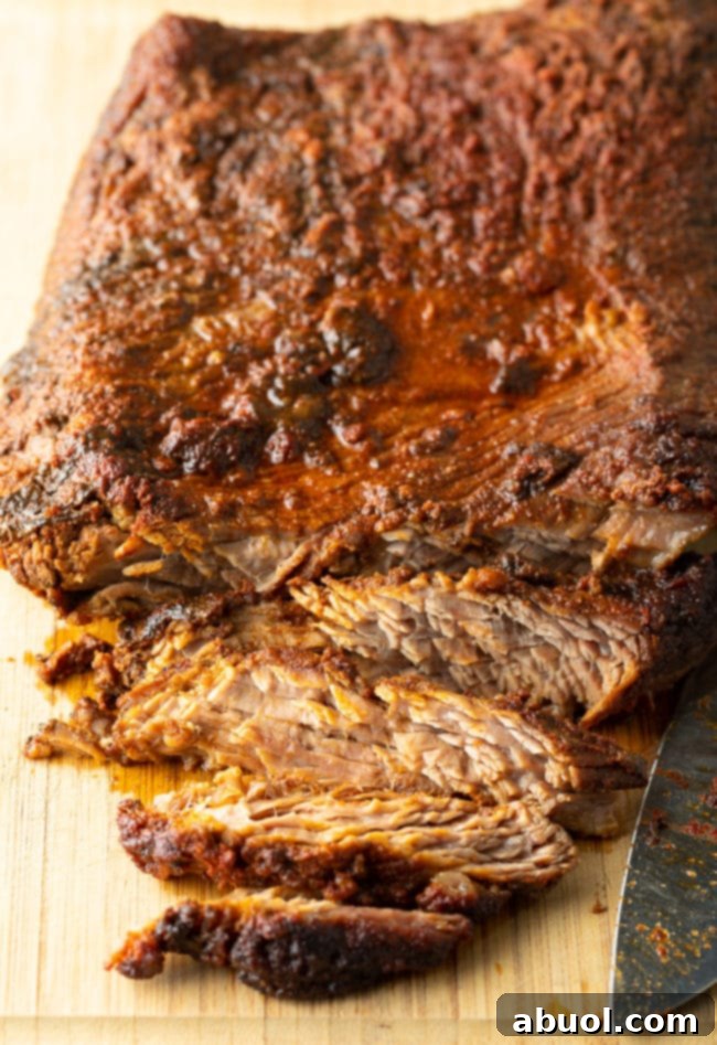 Expertly sliced beef brisket on a cutting board, showcasing its tender texture.