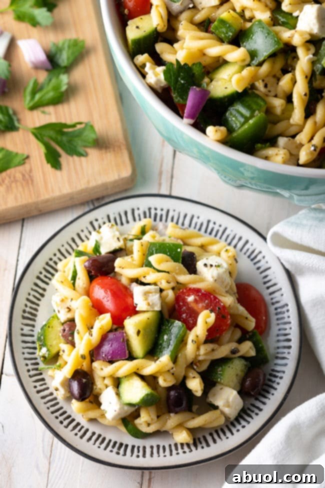 Best pasta salad piled on a plate with fresh ingredients surrounding it