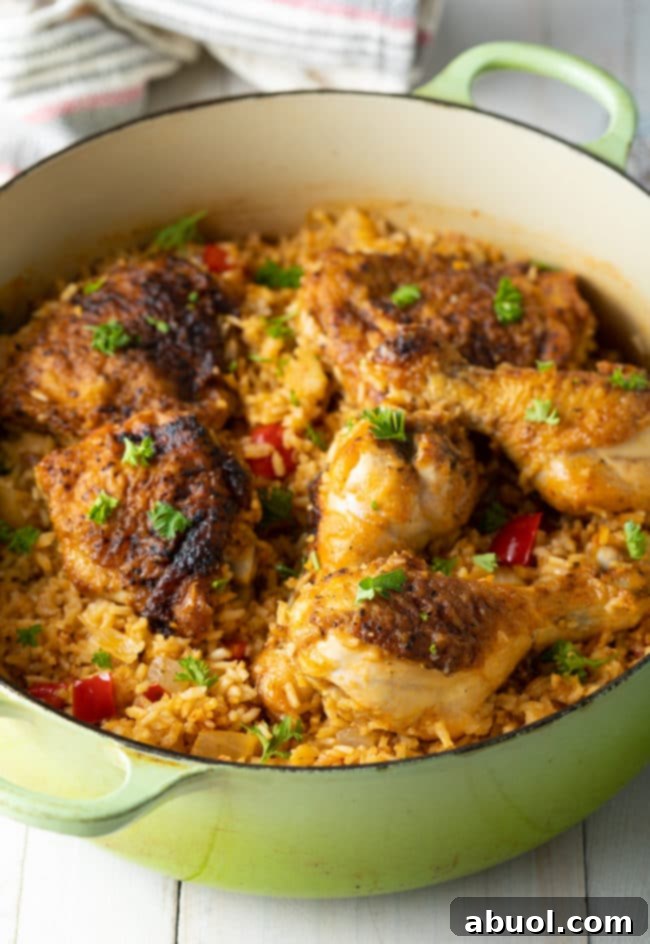 Authentic Cuban Arroz Con Pollo 4 Arroz Con Pollo Cubano cooking in a large dutch oven, steam gently rising.