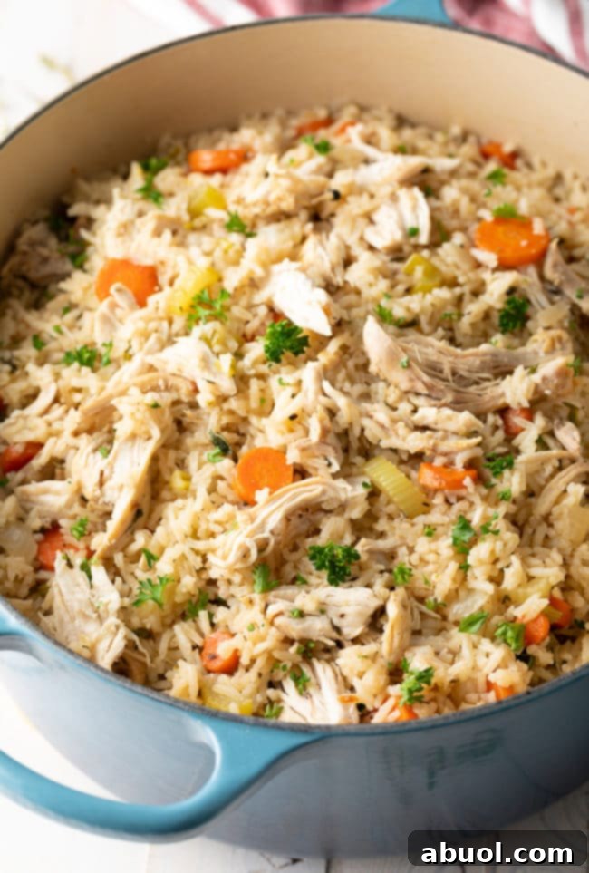 A large serving spoon scooping out creamy chicken and rice.