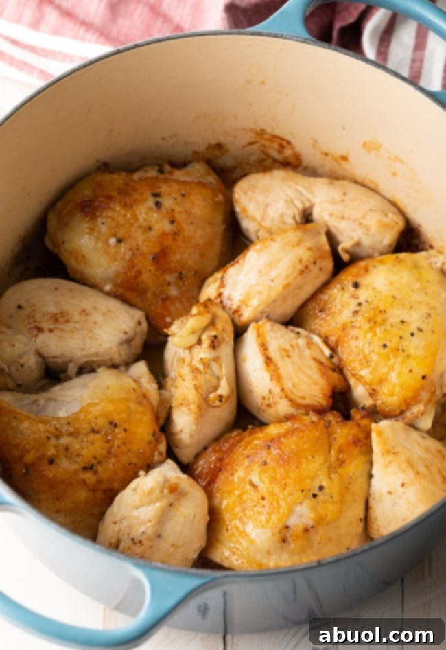 Browned chicken in a pot, creating a flavorful base.