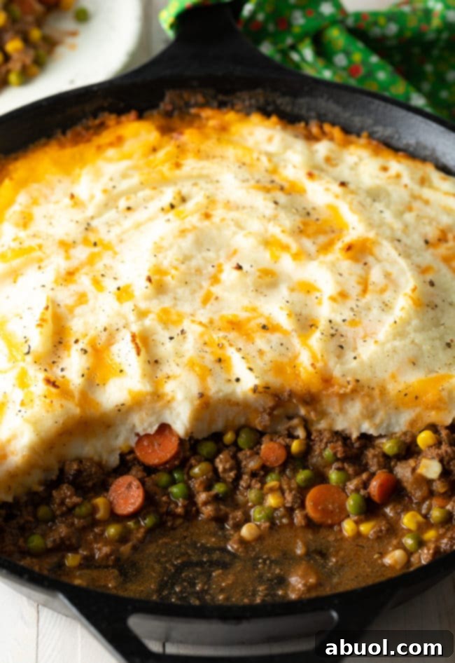 A freshly baked Cottage Pie in a cast iron skillet, golden-brown and bubbling, ready to be served.