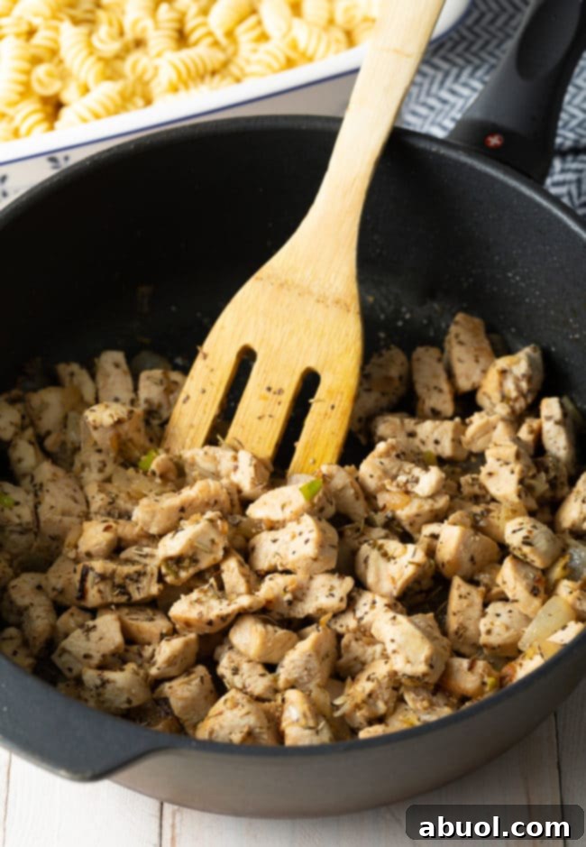 Effortless No-Boil Chicken Parmesan Pasta 6 Cubes of chicken being sautéed in a pot with italian seasoning.