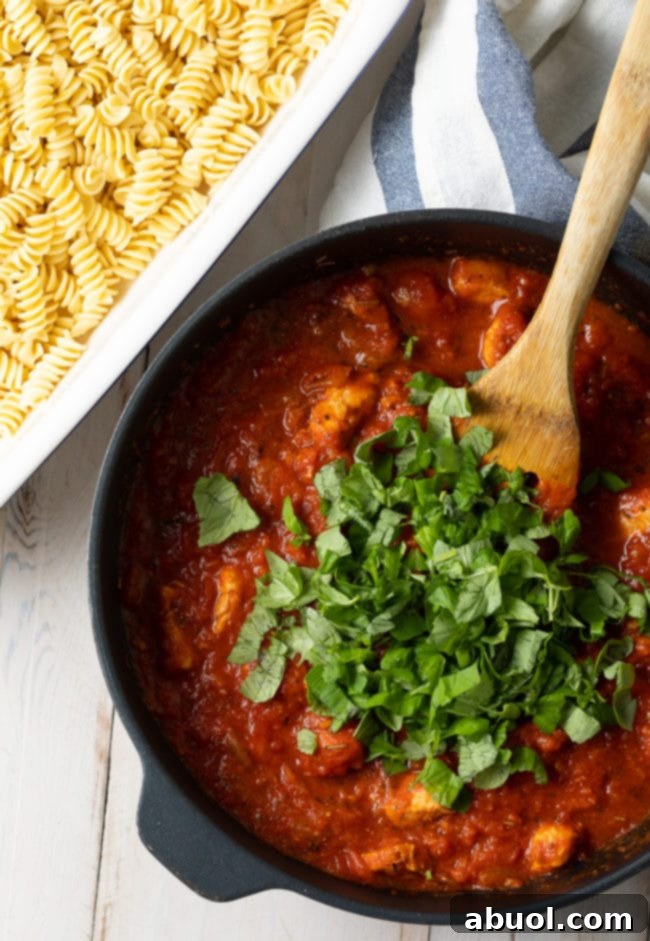 Effortless No-Boil Chicken Parmesan Pasta 7 Pasta sauce with chicken in the pot topped with fresh basil.
