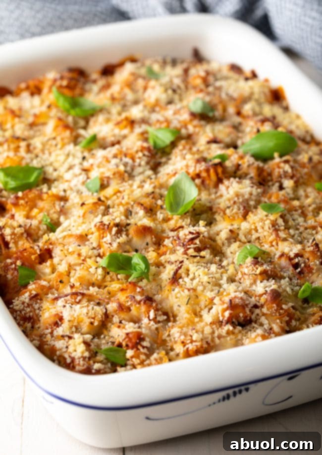 Effortless No-Boil Chicken Parmesan Pasta 10 Baked Chicken Parmesan Pasta in a baking dish after being baked and topped with fresh basil.
