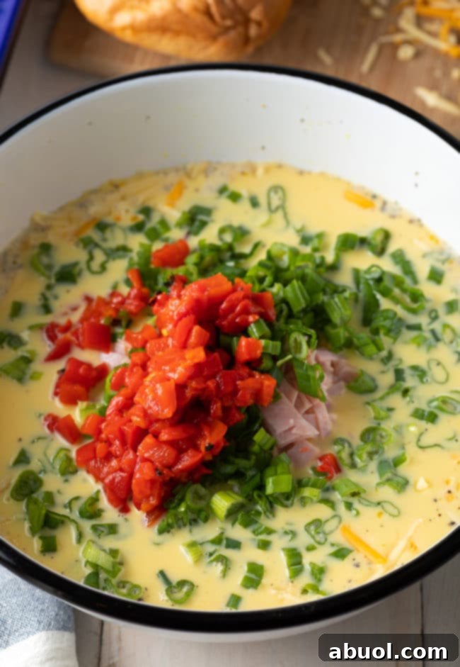 Egg mixture for strata recipe, showing whisked eggs, milk, and spices in a bowl