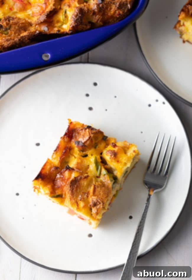 Make-ahead breakfast (overnight breakfast casserole) cut into pieces and served on black and white plates