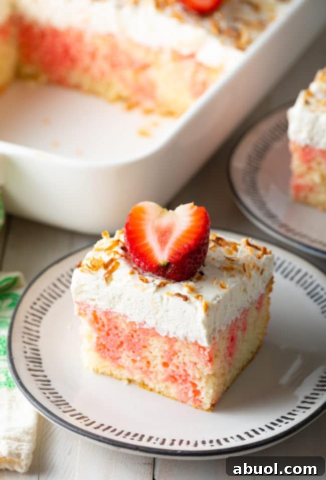 Strawberry Jello Cake Recipe, cut and placed on black and white plate, showing the jello infusion.