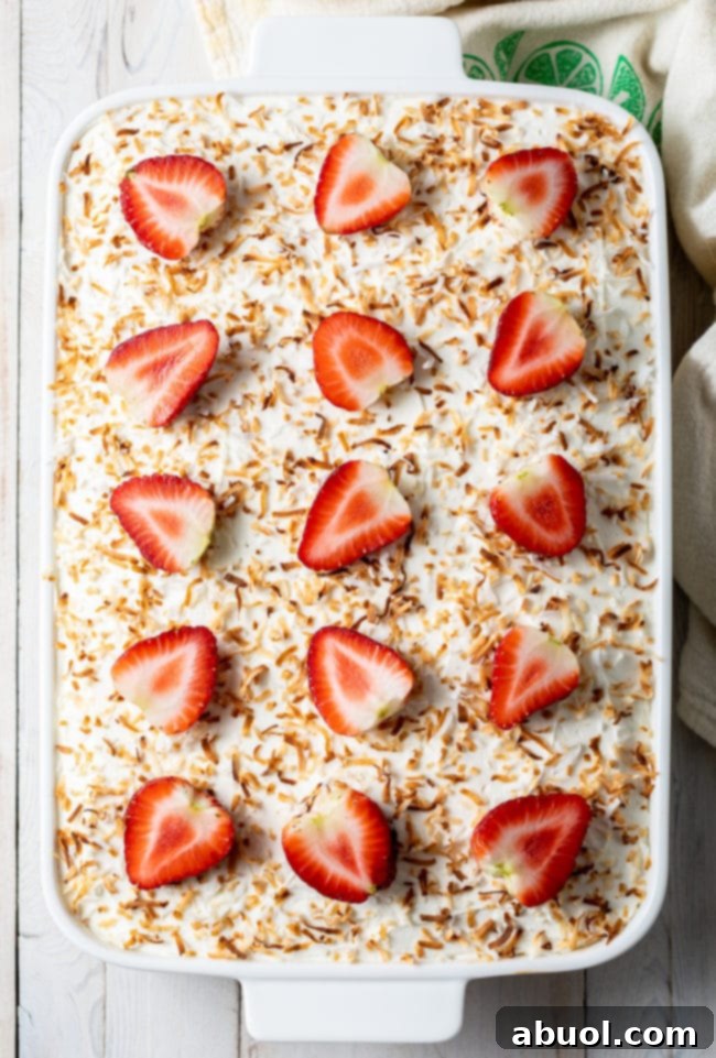 Strawberry Jello Cake with Pineapple and Coconut in white cake pan. Ready for chilling.