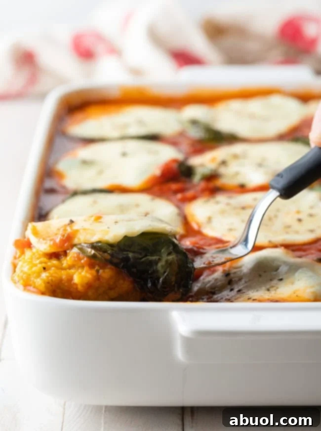 Lifting a square of polenta out of a baking dish.
