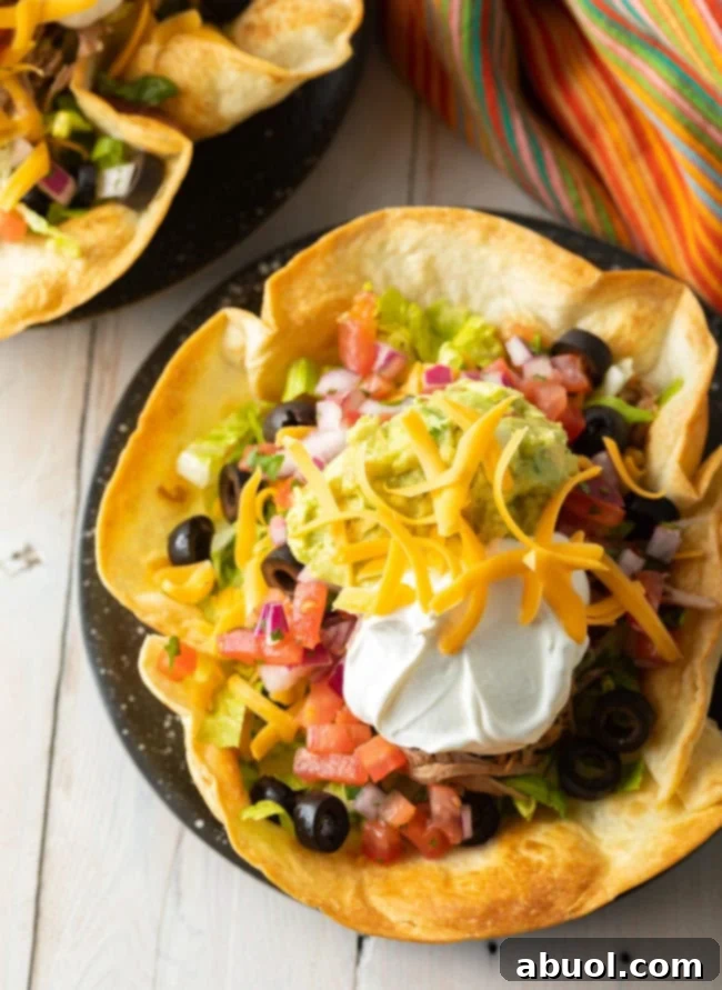 Overhead shot of a vibrant taco salad nestled in a homemade tortilla bowl, brimming with fresh ingredients.