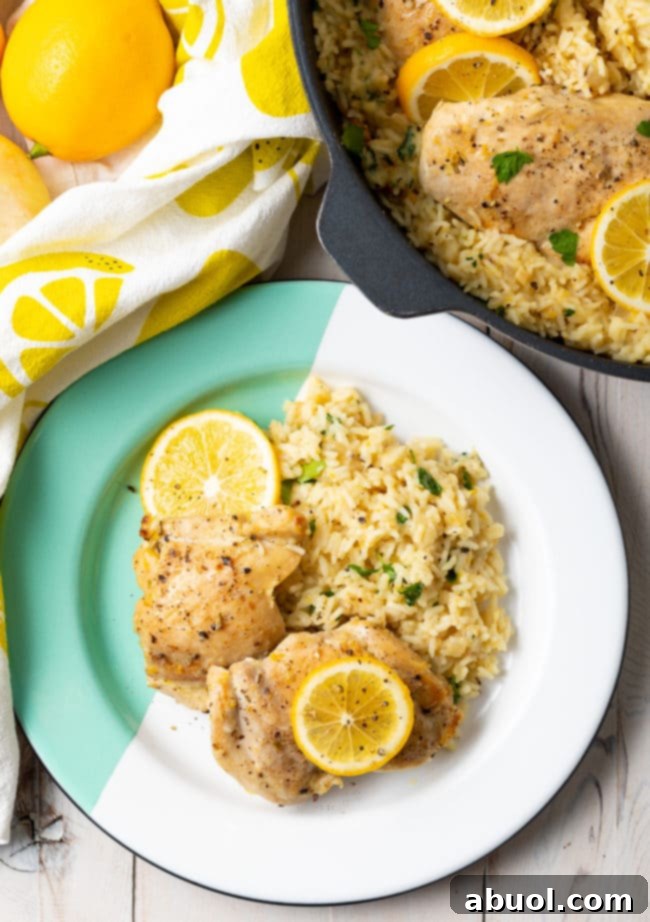 A close-up view of fresh ingredients for lemon chicken parmesan rice skillet, including vibrant lemons, a sweet onion, and garlic cloves.