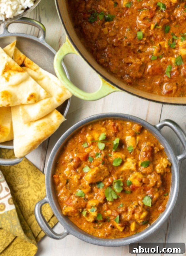 Fiery South Indian Chicken Curry 2 Easy Chicken Curry Recipe - Madras curry in a Dutch oven with more in a bowl next to some naan bread.