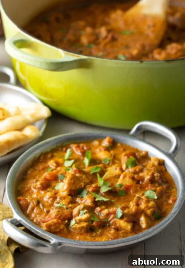 Fiery South Indian Chicken Curry 12 Easy Madras Chicken in a bowl next to a dutch oven full of curry.
