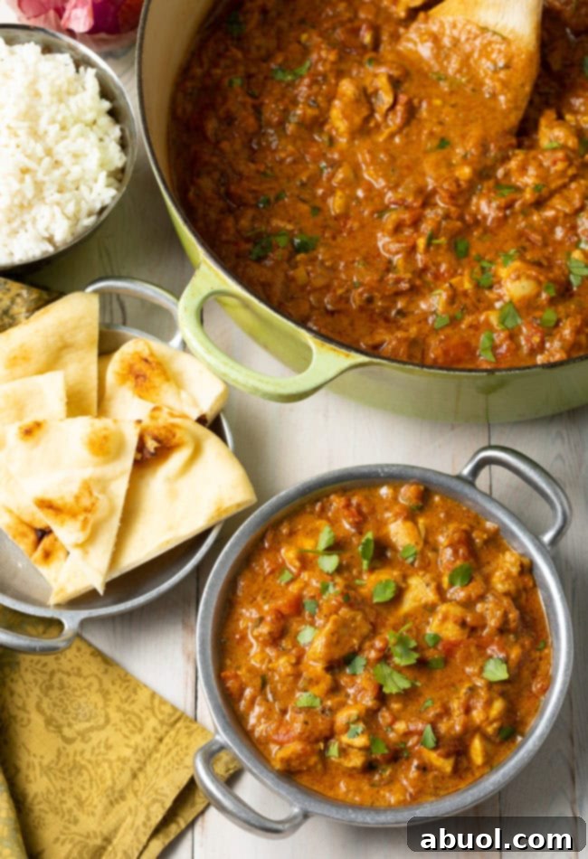 Fiery South Indian Chicken Curry 13 Madras-style chicken curry in a bowl next to naan bread.