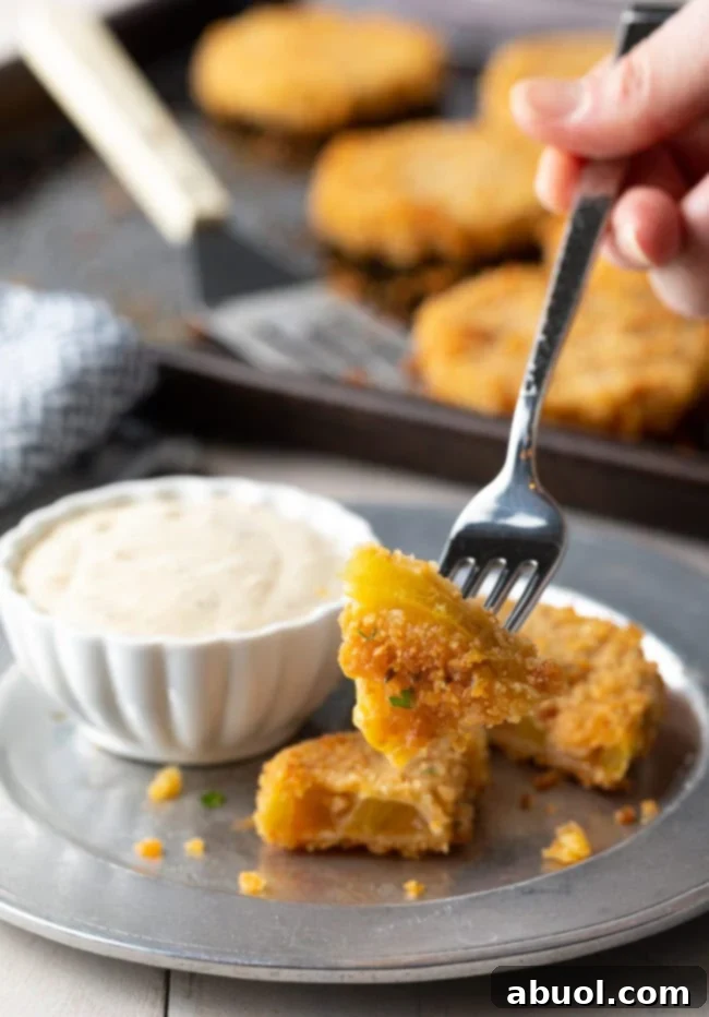 Fork with a piece of crispy fried green tomato on it. 