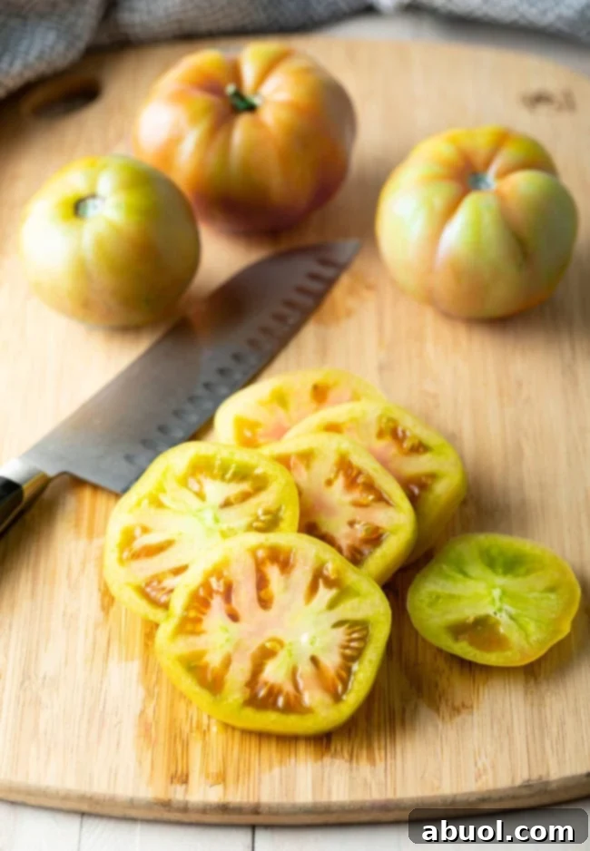 Sliced green tomatoes on a wooden cutting board. 