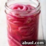 A jar of freshly made quick pickled red onions, ready to be enjoyed as a vibrant and tangy topping